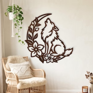 May include: A dark brown laser-cut wooden wall art piece featuring a howling wolf silhouette positioned within a crescent moon shape, decorated with floral and leaf motifs. The cutout design is mounted on a plain, light-colored wall surface.