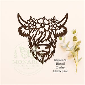 Puede incluir: Una silueta de cabeza de vaca Highland de madera marr&oacute;n oscuro cortada con l&aacute;ser con una corona floral entre los cuernos. El texto dice: Designed to cut 29.5cm tall (12 inches) but can be resized. Un logo de Monarch SVG Studio es visible.
