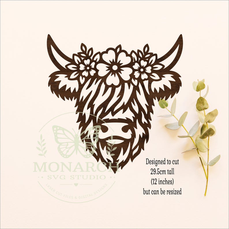 Puede incluir: Una silueta de cabeza de vaca Highland de madera marr&oacute;n oscuro cortada con l&aacute;ser con una corona floral entre los cuernos. El texto dice: Designed to cut 29.5cm tall (12 inches) but can be resized. Un logo de Monarch SVG Studio es visible.