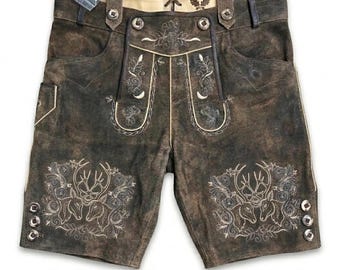 Könnte beinhalten: Dunkelbraune Lederhose mit aufwendiger cremefarbener Stickerei von Hirschen und floralen Motiven auf den Vorderteilen. Das Kleidungsstück verfügt über Hosenträger, eine Schnürung am hinteren Bund und drei Metallknöpfe an jedem Beinabschluss.