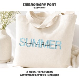 May include: A cream-colored canvas tote bag featuring the embroidered text SUMMER in light blue block letters with the word vibe in black cursive script overlaid. The top text reads EMBROIDERY FONT + BX FORMAT and the bottom text reads 6 SIZES 11 FORMATS ALTERNATE LETTERS INCLUDED.