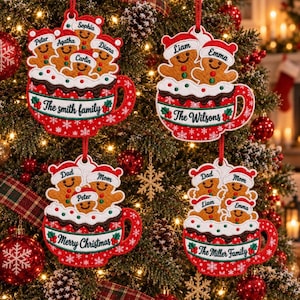 May include: Four red and white ceramic-style ornaments shaped like mugs filled with gingerbread people wearing Santa hats. Each mug features personalized text including The Smith family, The Wilsons, Merry Christmas, and The Miller family.