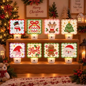May include: Eight square night lights with scalloped edges, each featuring a unique Christmas design including a snowman, ornament, reindeer, tree, Santa hat, the word Noel, gingerbread man, and Santa Claus, all mounted on white bases.