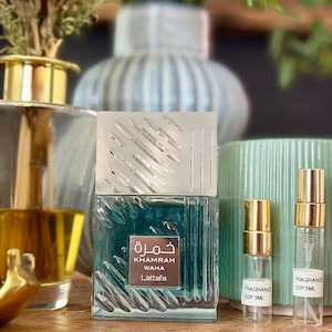 May include: A square glass perfume bottle with a textured surface and a silver cap, labeled Khamrah Waha Lattafa, accompanied by two small clear sample vials with gold caps labeled Fragrance EDP 3ML and Fragrance EDP 5ML respectively.
