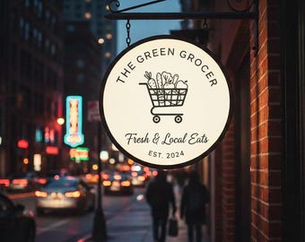 May include: A circular, illuminated sign for The Green Grocer featuring a black line-art shopping cart filled with produce. The text reads The Green Grocer, Fresh & Local Eats, and EST. 2024. The sign is mounted on a black metal bracket.