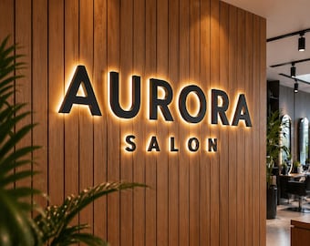 Puede incluir: El texto "AURORA SALON" en negro y con iluminación se muestra en una pared de madera. Las letras están delineadas con una luz cálida y dorada, creando un contraste llamativo. El interior del salón es visible en el fondo.