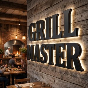 May include: Black "GRILL MASTER" sign with backlighting on a rustic wooden wall. The sign is in a restaurant setting, with tables and people dining in the background. The lighting creates a warm, inviting atmosphere.
