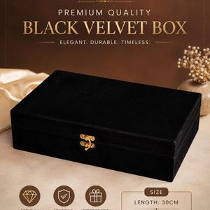 May include: A rectangular black velvet box featuring a gold-colored metal latch on the front. The text on the image reads PREMIUM QUALITY BLACK VELVET BOX, ELEGANT. DURABLE. TIMELESS. The box measures 30 cm in length and 20 cm in width.