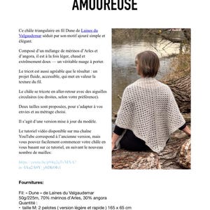 Peut inclure: Un châle triangulaire beige avec un motif ajouré, porté par une personne. Le châle est composé d'un mélange de laine mérinos et d'angora. Le texte "AMOUREUSE" est en haut de l'image.
