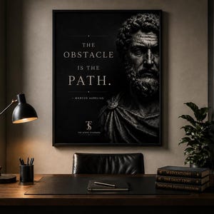 May include: A framed black and white print with the quote "The obstacle is the path" by Marcus Aurelius. The print hangs above a desk with a lamp, books, and a globe. The room has a classic, scholarly aesthetic.
