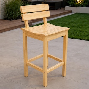 May include: A light-colored wooden bar stool featuring a square seat and a horizontal backrest slat. The stool is constructed with four straight legs connected by a square footrest frame, showcasing a natural wood grain finish throughout the piece.