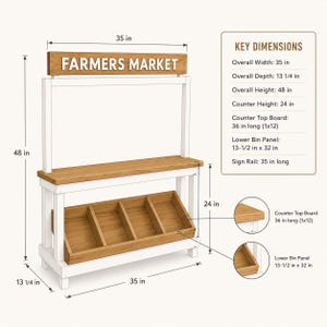 May include: A wooden farmers market stand with a white frame and natural wood finish. It features a top sign reading FARMERS MARKET, a flat counter, and four lower storage bins. Dimensions are 35 inches wide, 13.25 inches deep, and 48 inches high.