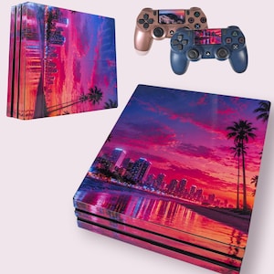 May include: A games console and two controllers, all featuring a sunset design. The console and controllers display a cityscape with palm trees, reflecting the sky's colours in pink, purple, and orange.