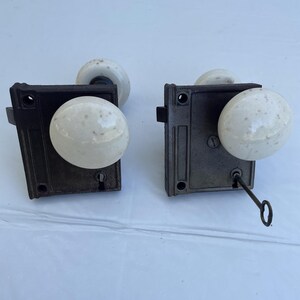 Antique cast iron and porcelain knob rim lock door knob pair with key