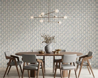 May include: An oval wooden dining table with four grey upholstered chairs, a grey vase with dried branches, and a modern multi-globe chandelier. The wall features a textured wallpaper with a blue and beige woven basket-weave pattern.