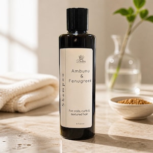 May include: A dark brown cylindrical shampoo bottle with a black cap and a cream-colored label. The label features the text Butlers, Ambunu & Fenugreek, Shampoo, For coils, curls & textured hair, and 8 fl ounces in black lettering.