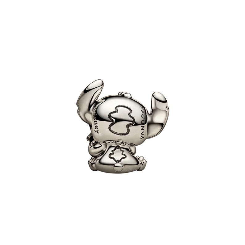 May include: A polished silver charm shaped like the character Stitch, featuring large ears and a rounded head. The side of the head is engraved with the text Disney and Pandora, while the base includes a small 925 ALE hallmark stamp.
