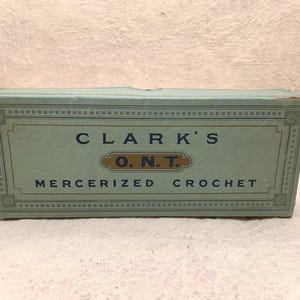 May include: A green box with a white border and gold lettering. The box reads "Clark's O.N.T. Mercerized Crochet".