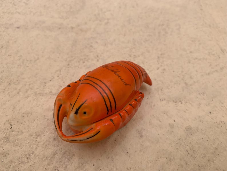 May include: Orange and black ceramic lobster figurine with the word "Atlantic City" written on the top.