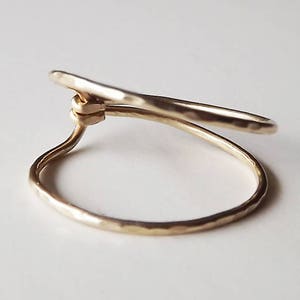 May include: A gold-toned ring with a hammered finish, featuring a unique twisted design.