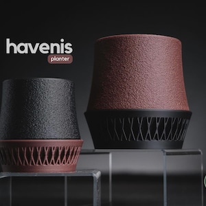 May include: Two planters labeled havenis planter. The smaller one is black with a reddish-brown base featuring a lattice pattern. The larger one is reddish-brown with a black base featuring a lattice pattern. Both have a textured, granular finish.