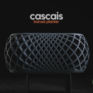 May include: A dark gray bonsai planter with a complex, repeating lattice grid pattern. The text "cascais bonsai planter" appears in white and orange above the object, and a small green circular logo with "h3liø design" is in the corner.