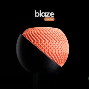 May include: A contemporary planter featuring a spherical, coral-coloured, textured design. The planter is partially enclosed in a black, semi-circular base. The word "blaze" is above the planter, with "planter" below it. The background is black.