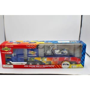 May include: A toy truck and motorcycle set. The blue and red truck has the Sunoco logo and the words "2006 Racing Bike & Transporter" on the side. A blue and silver motorcycle sits on the trailer.