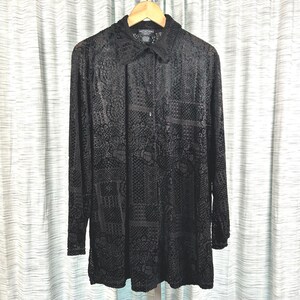 May include: A long-sleeved black button-down shirt featuring a semi-sheer, intricate tonal lace pattern throughout. The garment includes a standard collar, a front button placket, and a straight hemline, showcasing a consistent dark texture.