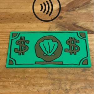 May include: A rectangular green sign featuring a black dollar sign on the left and right sides, with a central black circular emblem containing a green seashell graphic. Above the sign is a black circular icon with four curved lines.