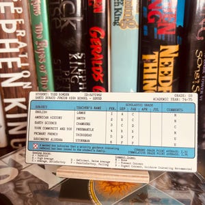 May include: A rectangular student report card for Todd Bowden, ID 8271982, from Santo Donato Junior High School, grade 08, academic year 74-75. The card lists subjects, teachers, and grades for September and January, with a cumulative grade point average of 1.75.