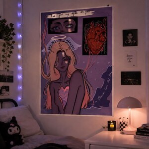 Könnte beinhalten: Ein großes Poster mit lila Hintergrund zeigt eine Illustration einer Frau mit blonden Haaren und einem herzförmigen Design auf der Brust. Der Text "I've got my eyes on you" steht oben. Zusätzliche Kunstwerke und Fotos befinden sich an der Wand.