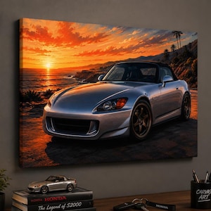 May include: A rectangular canvas print featuring a silver Honda S2000 sports car parked on a coastal road at sunset. The vibrant orange sky reflects over the ocean waves, while the car is positioned in the foreground with dark wheels.