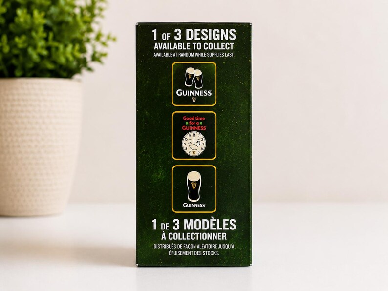May include: A dark green box with the Guinness logo and text. The box displays three different designs available to collect. The text reads "1 of 3 designs available to collect" and "available at random while supplies last."