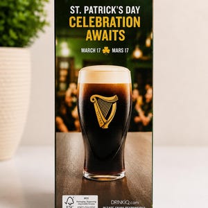 May include: A St. Patrick's Day themed box featuring a pint of dark stout with a foamy head. The box has text that reads "ST. PATRICK'S DAY CELEBRATION AWAITS" and "MARCH 17". The Guinness harp logo is visible.