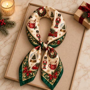 May include: A cream-colored silk scarf featuring a festive holiday print with nutcrackers, red trucks carrying Christmas trees, mugs of hot cocoa, snow globes, and wreaths. The scarf has a dark green border with gold accents and star motifs.