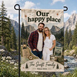 May include: A rectangular garden flag featuring a mountain landscape background with a couple standing in the center. The text reads Our happy place, The Swift Family, Since 2022, and Life is better with adventures. Includes a lantern and mug graphic.