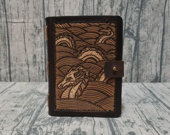 Leather and wood adventure tome hollow book dice box with sea serpent loch ness carving on cover