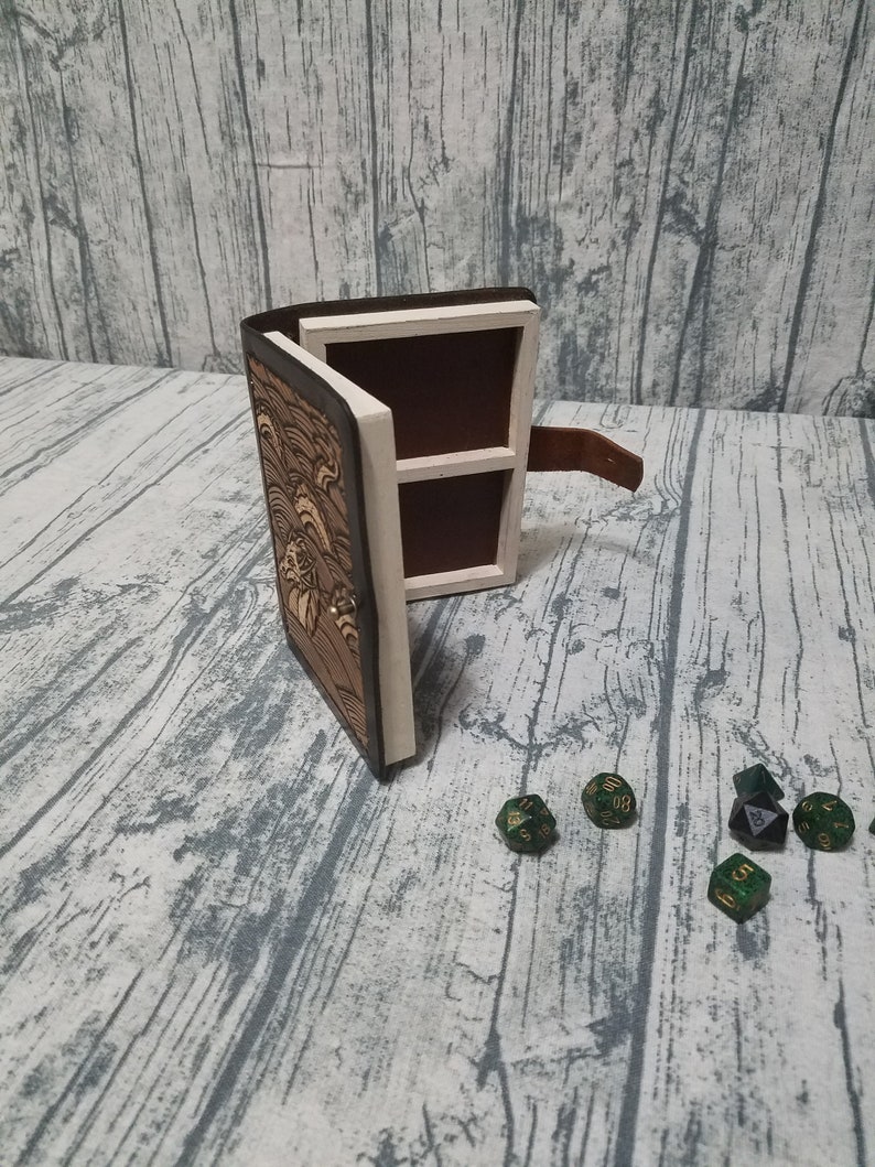Leather and wood adventure tome hollow book dice box with sea serpent loch ness carving on cover