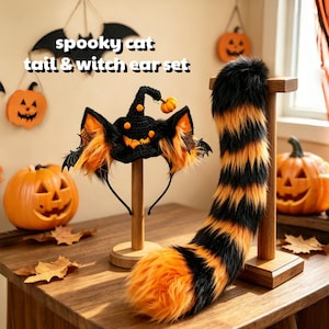 Puede incluir: Una cola de piel sintética negra y naranja y una diadema de sombrero de bruja con orejas de gato. El sombrero presenta un pequeño adorno de calabaza y detalles de telaraña. El texto "spooky cat tail & witch ear set" es visible en la esquina superior.