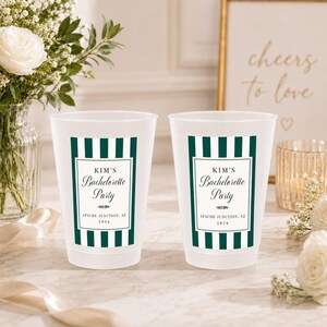 May include: Two frosted plastic cups featuring a dark green and white vertical striped border. The center label displays the text KIM'S Bachelorette Party, a decorative flourish, and the location and year, APACHE JUNCTION, AZ 2026.