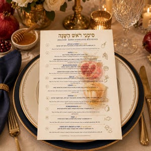 May include: A festive table setting with a menu titled "SIMANIM - ROSH HASHANAH BLESSINGS". The menu features illustrations of apples, pomegranates, and other foods. A white plate with a gold rim is in the foreground, with a gold fork and knife.
