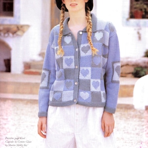 May include: A long-sleeved button-down cardigan featuring a patchwork pattern of light blue, medium blue, and grey squares, each containing a heart motif. The garment has a collared neckline and solid blue sleeves, paired with white striped shorts.