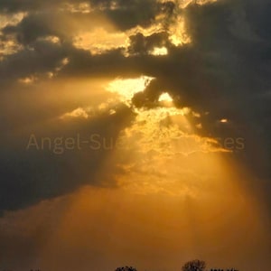 May include: A dramatic sunset scene with dark, ominous clouds and golden sunlight breaking through. The text "Angel-Sue" is visible in the image. A silhouette of trees and a horizon line complete the landscape.