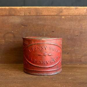 1900s “A Penny Saved” Embossed Tin Coin Bank – Early Folk Art Savings Storage Box in Original Red Paint.