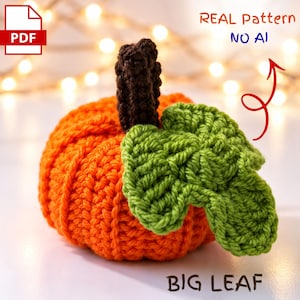 Puede incluir: Un patrón de calabaza a ganchillo en PDF que muestra una calabaza naranja brillante con un tallo marrón oscuro y una hoja grande verde. La imagen incluye el texto REAL Pattern NO AI y BIG LEAF con una flecha roja hacia la hoja.