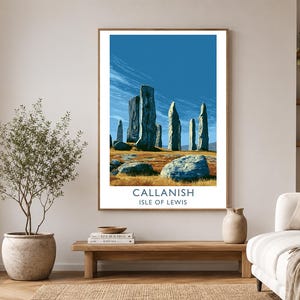 May include: A framed print of the Callanish standing stones on the Isle of Lewis. The artwork features a blue sky, tall stone structures, and a landscape of brown and yellow grass. The text "Callanish Isle of Lewis" is at the bottom.