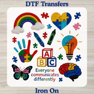 May include: A sheet of DTF Transfers featuring colorful graphics including a rainbow, puzzle heart, handprint, crayons, ABC blocks, lightbulb, butterfly, and brain. The text reads DTF Transfers, Everyone communicates differently, and Iron On.