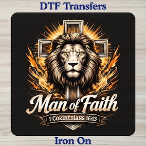 May include: A DTF transfer featuring a lion head centered in front of a cross with orange flames. The text reads Man of Faith and 1 Corinthians 16:13. The design is on a black background with the words DTF Transfers and Iron On at the top and bottom.