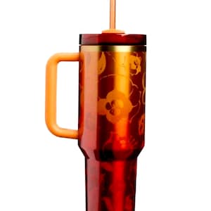May include: A tall, cylindrical tumbler with a metallic red finish and a repeating orange floral pattern. It features a sturdy orange side handle, a gold-toned rim, a dark red lid, and a matching orange straw extending from the center of the top.